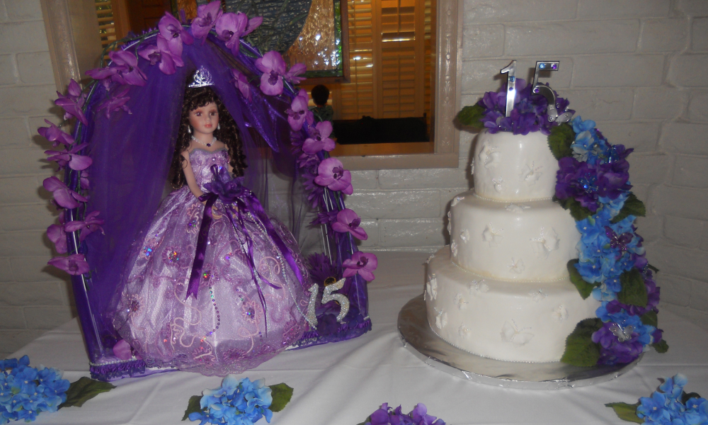 A decorated table with a birthday cake for a Quinceañera birthday celebration.