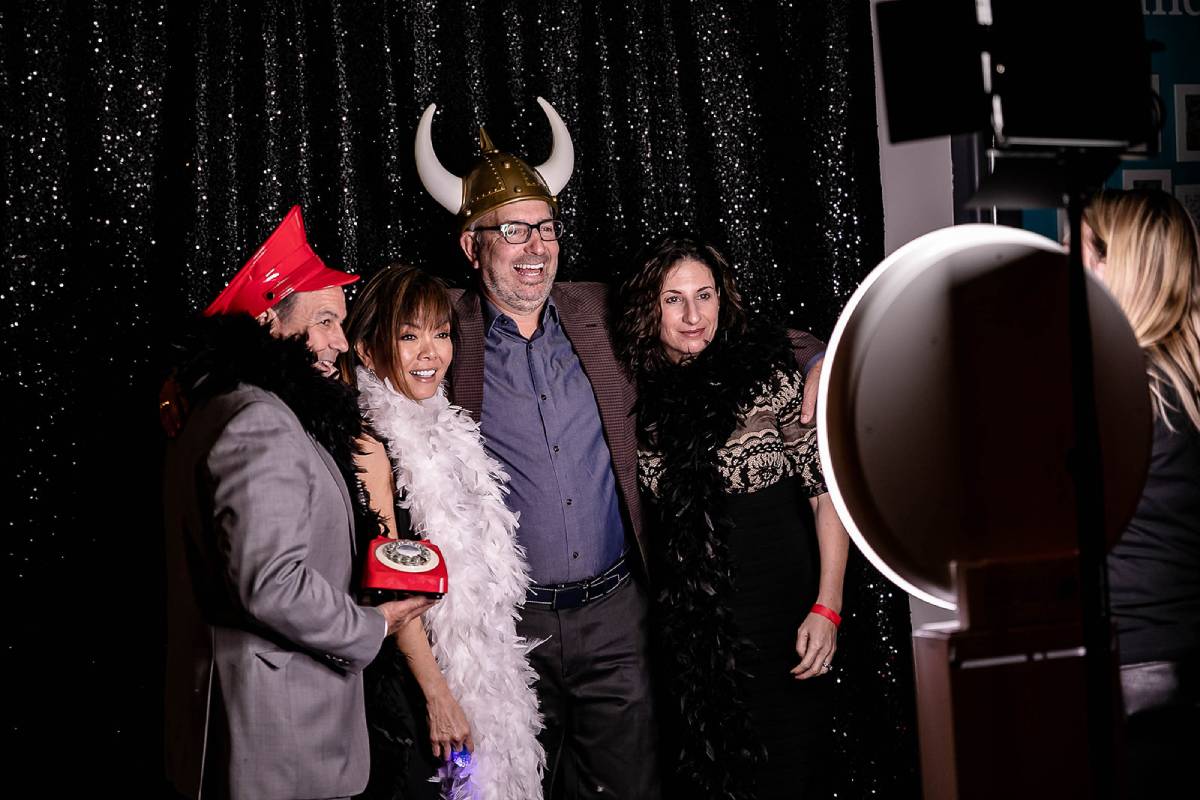 Happy employees pose at a photo booth.