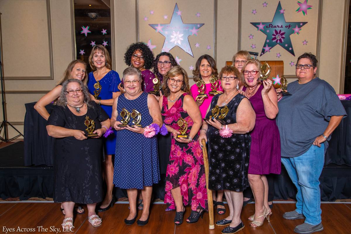 Star employees with awards at a corporate event.